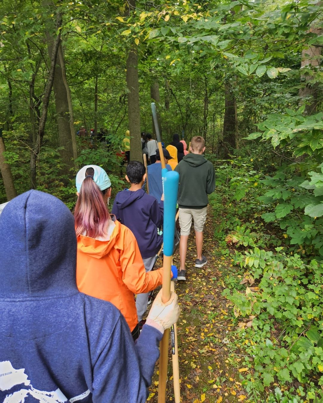 A group of students walk down a trail.